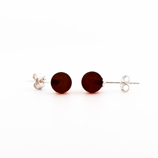 STUDS, Auskarai su natūraliu Baltijos gintaru.   Poliruotos, apvalios formos natūralaus gintaro detalės.  Gintaro diametras: 5 – 7 mm.  Išmatavimai: 5-7mm x 18 mm.  Tamsios vyšnios spalva.  Metalas: Ag 925 Sidabras.