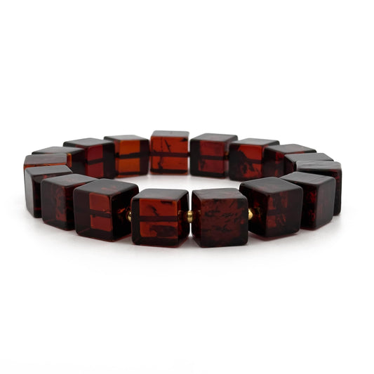 CUBO, natūralaus gintaro apyrankė.
poliruotos, kubo formos, gintaro detalės su paauksuoto sidabro intarpais.
Detalių diametras: 9 - 9.5 mm.
Vidinis Ilgis: 16 – 21 cm.
Suverta ant elastingos, silikoninės gumos.
Be užsegimo.