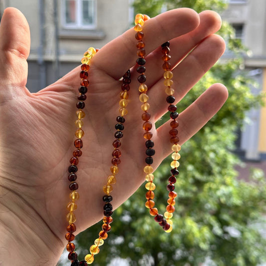 Gintaro Vėrinys Vaikams – Trispalvis (Citrina – Konjakas – Vyšnia) – „Baroko“ formos, poliruoto arba matinio paviršiaus

Šis trispalvis Baltijos gintaro vėrinys vaikams – tai išskirtinis, spalvingas ir natūralus papuošalas, sukurtas iš trijų derančių gintaro atspalvių: skaidrios citrinos, šiltos konjako ir sodrios vyšnios. Karoliukai suverti pasikartojančia seka po tris – tai ne tik estetiška, bet ir ritmiškai harmoningas dizainas. Puikiai tinka vaikams ir paaugliams, vertinantiems natūralų grožį bei išskir