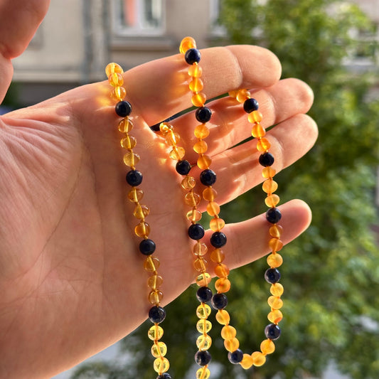 Gintaro Vėrinys Vaikams – Citrina + Lazuritas
Šis gintaro ir akmens vėrinys vaikams traukia akį kontrastingu ir karališku deriniu. Skaidri, šviesi citrinos spalvos gintaro šiluma dera su sodriai mėlynu lazuritu, kuris nuo senų laikų laikomas išminties, ramybės ir dvasinės stiprybės simboliu. Karoliukai suverti ritmingai: trys gintaro ir vienas lazurito – subtili harmonija visame vėrinyje.

Savybės:
100 % natūralus Baltijos gintaras – skaidri, šviesi citrinos spalva.

Spalvų derinys: citrina + mėlynas lazuri