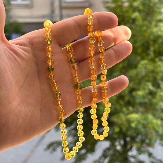Gintaro Apyrankė Vaikams – Citrinos Spalva ir Peridotas
Ši natūralaus Baltijos gintaro apyrankė vaikams ir paaugliams suverta iš šviesios citrinos spalvos gintaro karoliukų ir gaivaus žalio peridoto. Tai subtilus, šviesus ir vasariškai lengvas derinys, kuris skleidžia šilumą, ramybę ir natūralų žavesį – puikiai tinka tiek berniukams, tiek mergaitėms.

Savybės
100 % natūralus Baltijos gintaras – citrinos spalvos.

Dekoratyvinis akmuo: peridotas.

Karoliukų išdėstymas: 3 gintaro karoliukai + 1 peridoto akmuo 