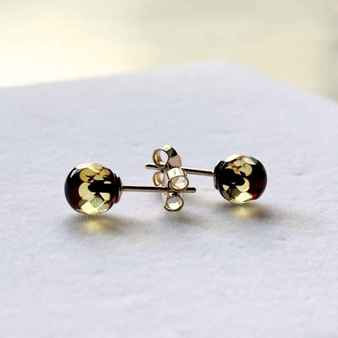 STUDS, Auksiniai auskarai - vinutės su natūraliu Baltijos gintaru. 

Poliruotos, apvalios facetuotos formos natūralaus gintaro detalės. 
Gintaro diametras: 7 mm. 
Kelių tonų spalva. 

Svoris: apie 0,96 g. 
Metalas: AU585 prabos geltonas auksas. 